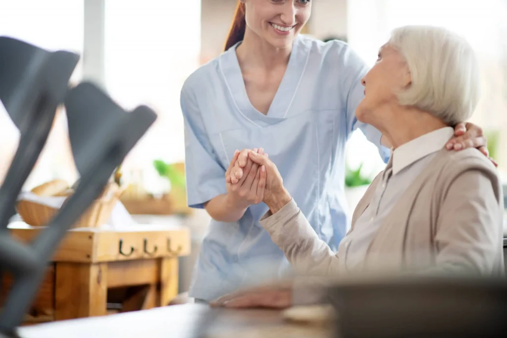 opiekunka seniorki trzema seniorkę za rękę