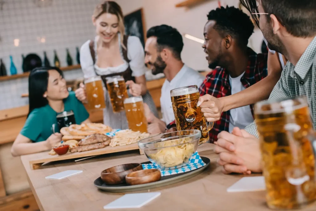 Octoberfest - w lokalu - święto piwa w Niemczech - kobieta obsługuje gości i przyniosła kufle z piwem